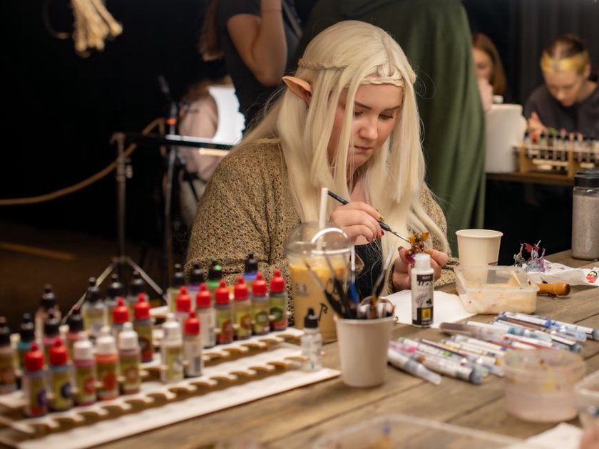 Des maquettistes travaillent autour de grandes tables