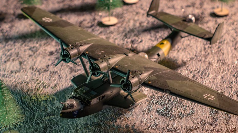 juges examinant un blindé et un avion sous une lampe lors d'un concours de modélisme