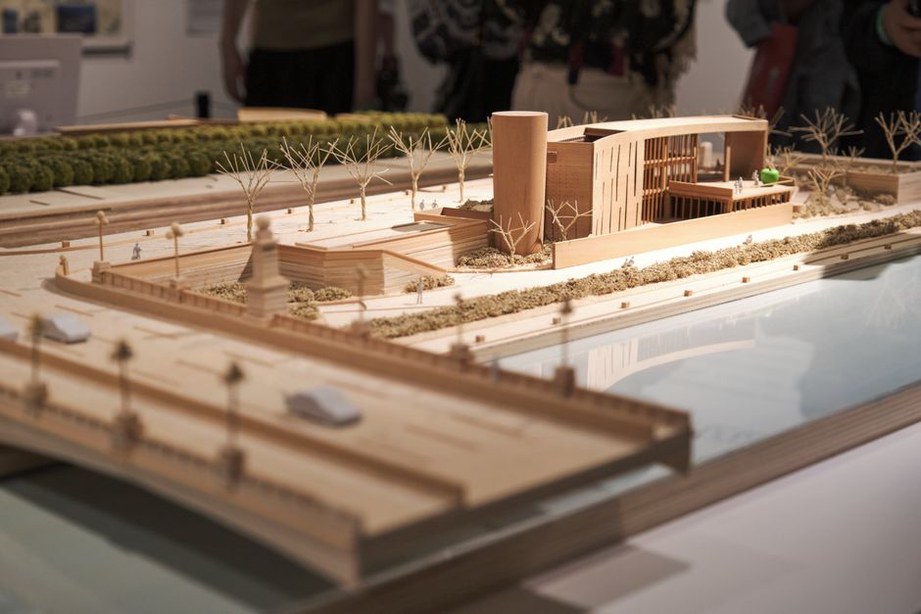 Exposition de maquettes avec des visiteurs admirant les créations
