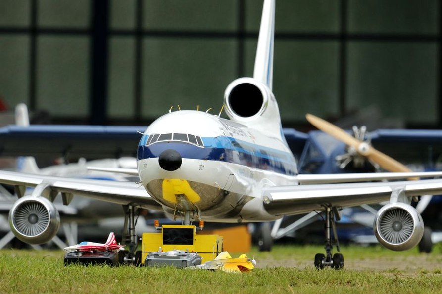Avions et blindés miniatures alignés sur les tables d’exposition